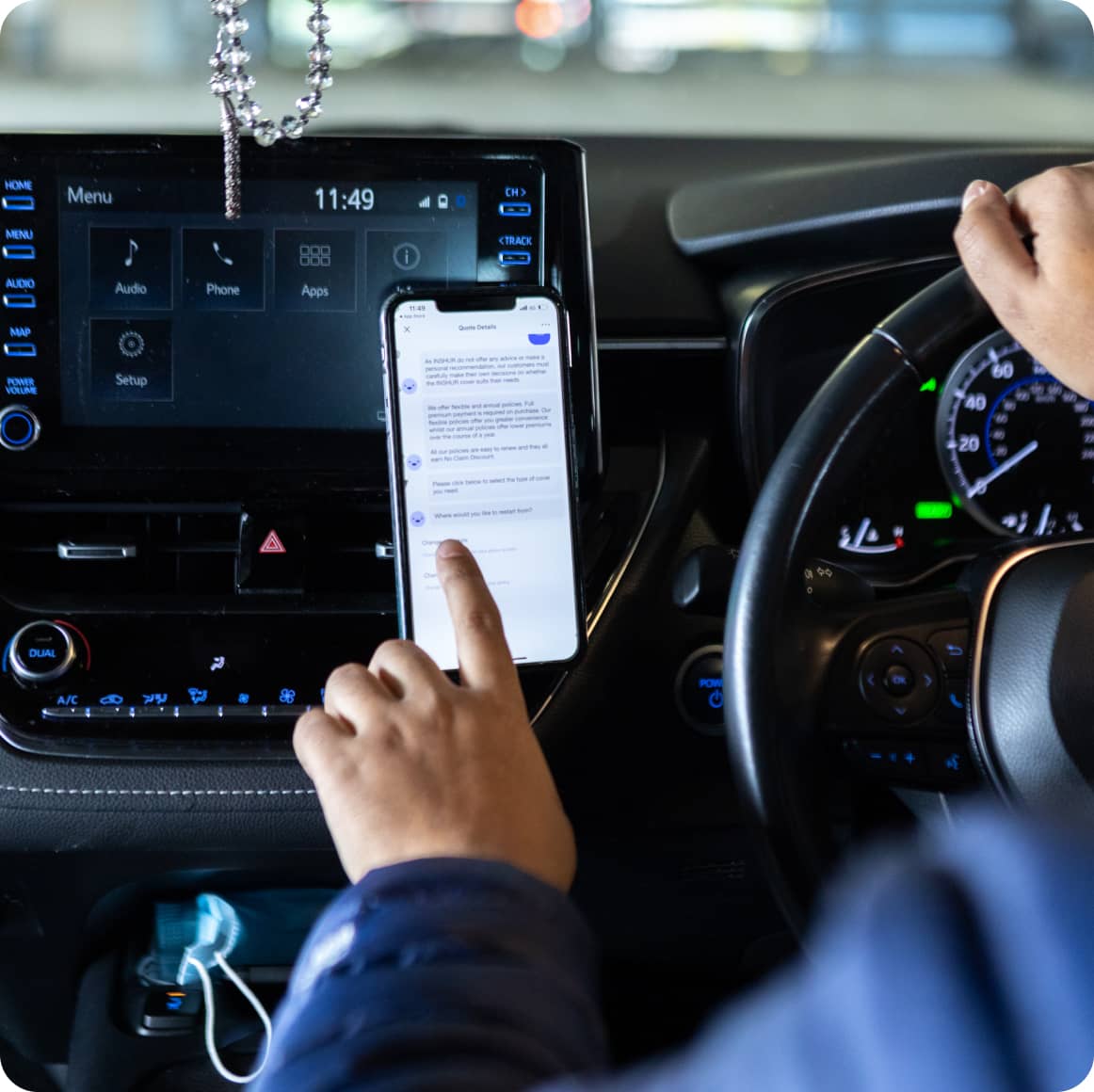 Driver sitting in car using his phone to input directions