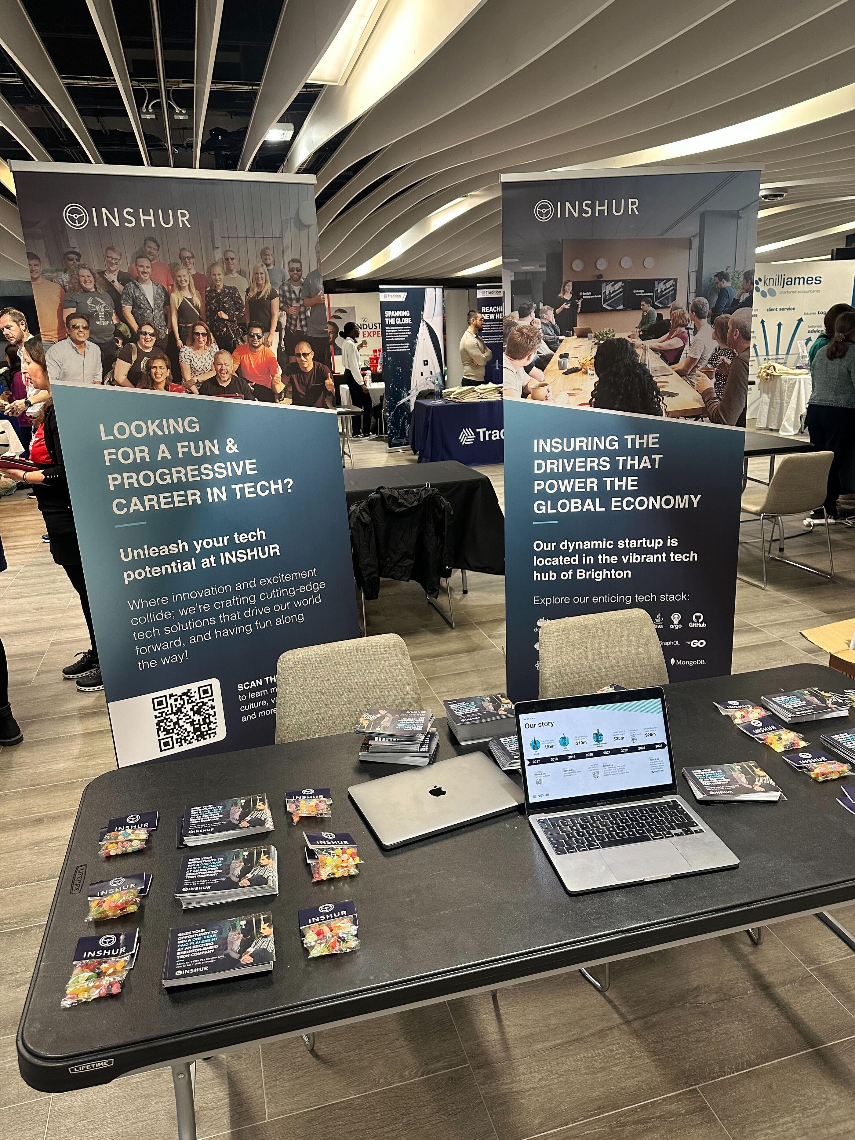 a table at a careers fair showing two banners with information about INSHUR